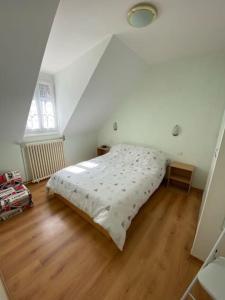 een slaapkamer met een groot bed op zolder bij Appartement 4-6 personnes calme proche centre-ville SLT in La Bourboule