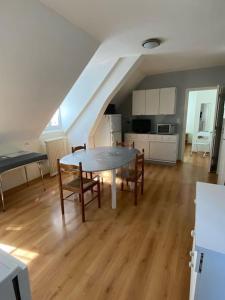 ein Wohnzimmer mit einem Tisch und Stühlen sowie eine Küche in der Unterkunft Appartement 4-6 personnes calme proche centre-ville SLT in La Bourboule