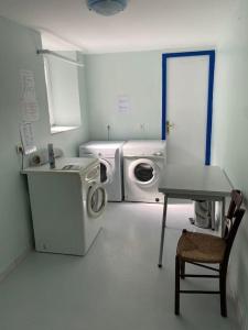 een wasruimte met een wasmachine en een tafel bij Appartement 4-6 personnes calme proche centre-ville SLT in La Bourboule