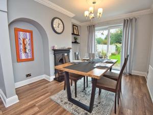 a dining room with a table and a clock on the wall at Cosy 3 bed with Parking- Family and Contractors in Birmingham