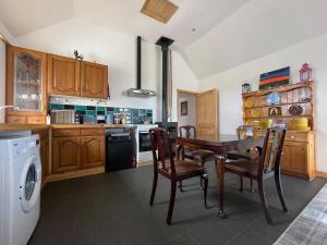 a kitchen with a table and chairs and a dishwasher at Mey Bee in Mey