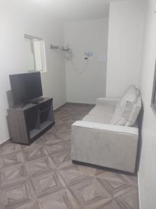 ein Wohnzimmer mit Sofa und Fernseher in der Unterkunft Apartamento Mar de São josé in São José da Coroa Grande