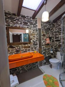 un bagno in pietra con lavandino e specchio di Casa do Estevo a Francos