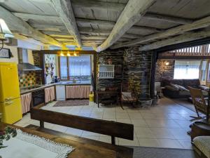 ein Wohnzimmer mit einer Bank und einer Küche in der Unterkunft Casa do Estevo in Francos