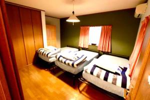 three beds in a room with green walls at Atorie Bekkan - Vacation STAY 13448 in Shiozawa