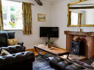 a living room with a couch and a fireplace at Church Cottage in Rigg