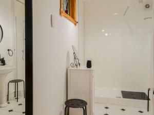 a bathroom with a white tub and two stools at Church Cottage in Rigg