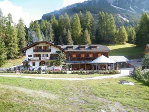 a large building in the middle of a field at Fattoria Meneguto Agriturismo Degasper Giorgio in Cortina dʼAmpezzo