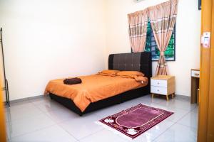 1 dormitorio con cama con sábanas de color naranja y ventana en Adorable 2-bedroom home with Wi-Fi, Netflix and BBQ grill, en Rembau