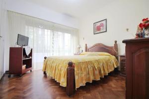ein Schlafzimmer mit einem Bett mit einer gelben Decke in der Unterkunft Departamento muy buena ubicacion in Buenos Aires