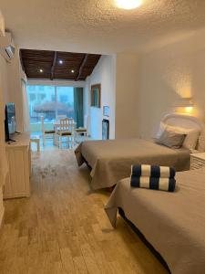 Habitación de hotel con 2 camas y comedor en Cancun Plaza Condo Apartment, en Cancún
