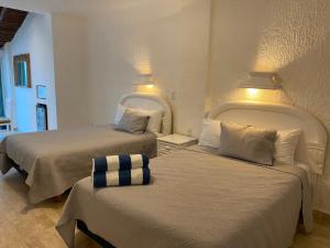 Dos camas en una habitación de hotel con dos en Cancun Plaza Condo Apartment, en Cancún