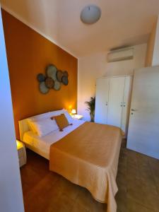 een slaapkamer met een bed en een gele muur bij Terrazza vicino al mare in Rimini