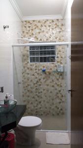 een badkamer met een glazen douche en een toilet bij Casa Cibratel 2 in Itanhaém