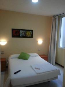 1 dormitorio con 1 cama blanca y 2 cuadros en la pared en Hostal Ancla Dorada, en Vigo