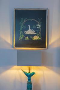 a painting of a swan in a pond next to a vase at Seafront Apartment Private Garden & Free Parking in Littlehampton