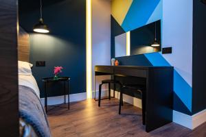 ein Schlafzimmer mit einem Schreibtisch und einer blauen Wand in der Unterkunft The Nest - Luxury 16 person Apt w jacuzzi & parking in Blackpool
