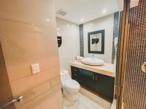 a bathroom with a toilet and a sink at Cancun Plaza Condo Ocean front in Cancún