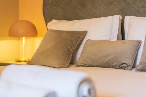 a close up of a bed with pillows and a lamp at Seafront Apartment Private Garden & Free Parking in Littlehampton