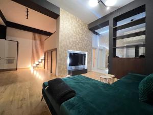 um quarto com uma cama verde e uma televisão de ecrã plano em Apartment House Nová Dubnica em Nová Dubnica
