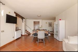 sala de estar con mesa y sillas y cocina en Villa con Piscina privata - Vista panoramica - 7 ROOMS - 20 GUEST, en Vaiano