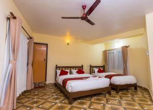 1 Schlafzimmer mit 2 Betten und einem Deckenventilator in der Unterkunft Hotel Stone House in Pokhara