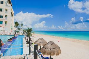 a resort with a swimming pool and a beach at Cancun Plaza Condo Ocean front in Cancún