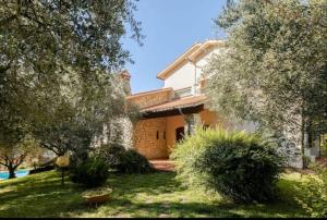 une maison avec une cour ornée de buissons et d'arbres dans l'établissement Villa con Piscina privata - Vista panoramica - 7 ROOMS - 20 GUEST, à Vaiano