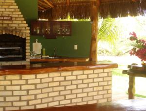 eine Küche mit einer Backsteintheke und einem Kamin in der Unterkunft Grimms Pousada de Contos in Porto de Sauipe