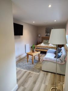 een woonkamer met een bed en een tafel bij Southwell Home Stay in Southwell