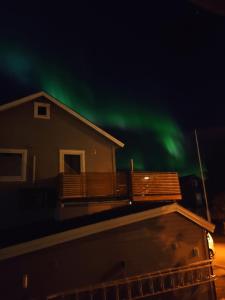 una imagen de una casa con la aurora en el cielo en FeelHome One bedroom apartment Vidarsveg en Tromsø