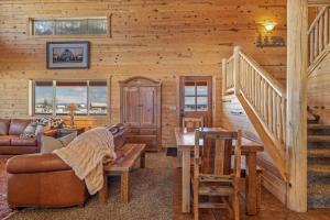 a log cabin with a staircase and a living room at Liberty Lodge by KABINO Hot Tub Air Hockey 3 Living Rooms 7 bedrooms Boat Launch Reservoir ATV Snowmobile Trails WiFi in Island Park