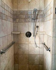a shower with a shower head in a bathroom at Riverwalk Retreat: Spacious, Hot tub, near Autzen in Springfield