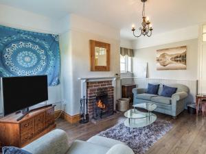 a living room with a fireplace and a tv at Horseshoes House in Watton