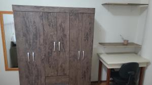 um grande armário de madeira num quarto com uma secretária em Apartamento Tubal em Uberlândia