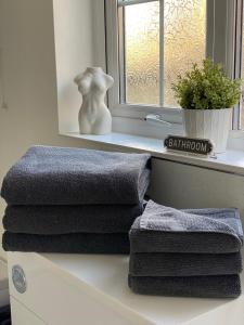 a stack of towels sitting on a counter next to a window at CODE Terrace Oulton Broad Suffolk in Oulton