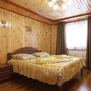una camera con un letto in una stanza con pareti in legno di ЗОЛОТА РИБКА a Slavske