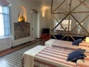 サンティアゴ・ド・カセーンにあるImpério Houseのベッドルーム(ベッド2台、テレビ付)