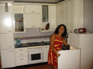 a woman standing in a kitchen next to a stove at La Alcandora in Granada