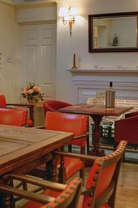 een eetkamer met een tafel en stoelen en een spiegel bij Best Western The George Hotel, Swaffham in Swaffham