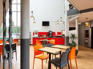 ein Esszimmer mit orangefarbenen Stühlen und einem Tisch in der Unterkunft Hôtel F1 Reims Tinqueux in Reims