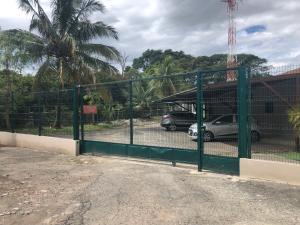 una puerta verde con coches estacionados en un estacionamiento en Departamento H González 2, en El Coco