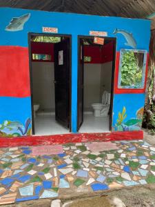 a blue bathroom with two doors and a toilet at Eco Hotel Las Palmeras in Isla Grande