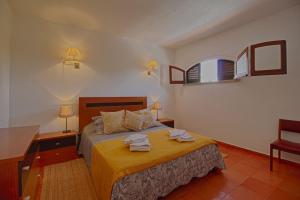 a bedroom with a bed with two towels on it at Apartamento Olhos D'Água VistaBella in Olhos de Água