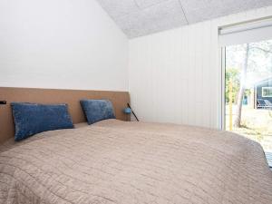 a bedroom with a large bed with blue pillows at Two-Bedroom Holiday home in Rømø 17 in Rømø Kirkeby