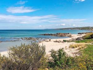 a sandy beach with the ocean in the background at 6 person holiday home in Allinge in Allinge