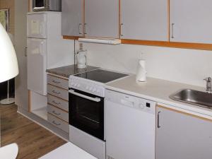 a white kitchen with a stove and a sink at 6 person holiday home in Aabenraa in Aabenraa