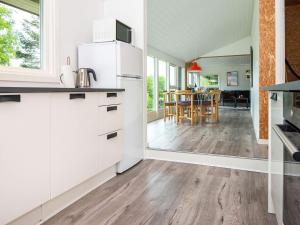 a kitchen with white cabinets and a dining room at 7 person holiday home in B rkop in Børkop