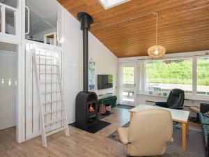 a living room with a fireplace and a table and chairs at 6 person holiday home in Aabenraa in Aabenraa