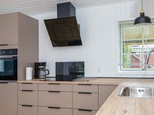 una cucina con lavandino e piano cottura forno superiore di 4 person holiday home in Juelsminde a Juelsminde